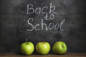 three juicy green Apple on blackboard background with inscription 