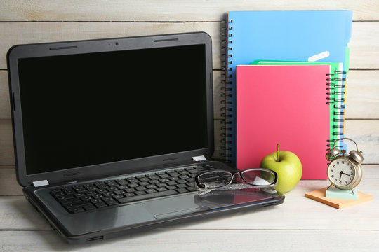 outdoor notebook near the notebook and glasses with Apple on white wooden table