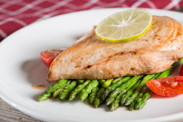 Grill chicken with asparagus, tomato and lemon slice. Selective