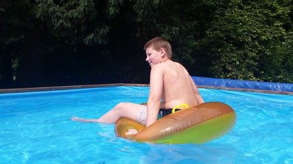 Junge hat Spaß beim Baden im Pool mit Schwimmring