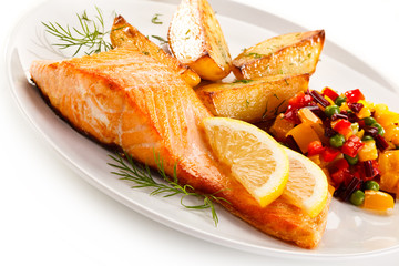 Fried salmon and vegetables on white background 