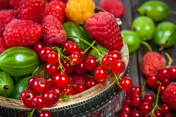 Mix of fresh organic berries isolated on vintage wooden table background