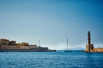 bay of Chania with lighthouse at sunny summer day, Crete, Greece. Yacht comes to the bay