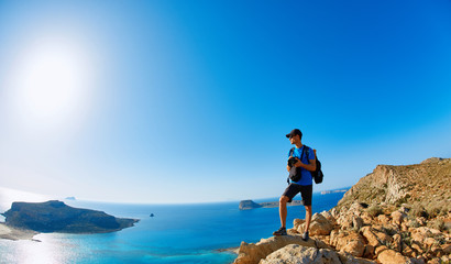 Obraz premium panoramic view on Balos beach, Crete, Greece. Man, traveller and photographer stands on the cliff