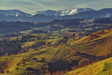 Fototapeta na wymiar Romanian rural landscape with traditional Romanian scattered houses in the valleys of Bucegi mountains uphill in Sirnea village, Brasov county, Romania.
