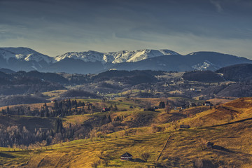Fototapeta premium Rural landscape with traditional Romanian neighborhoods in the valleys of Bucegi mountains uphill in Sirnea village, Brasov county, Romania.