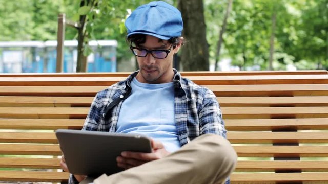man with tablet pc sitting on city street bench 6
