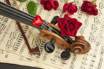 Fototapeta premium Old violin on wooden table. Detail of old violin. Invitation to the Violin Concerto. I love classical music. Sale of antique violins. 
