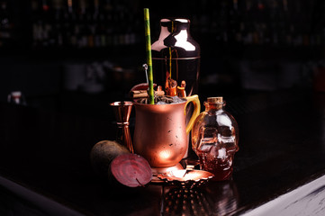 Refreshing summer punch and copper bar tools on dark background