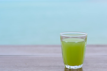 guava Juice on wood table with blur water sea background.