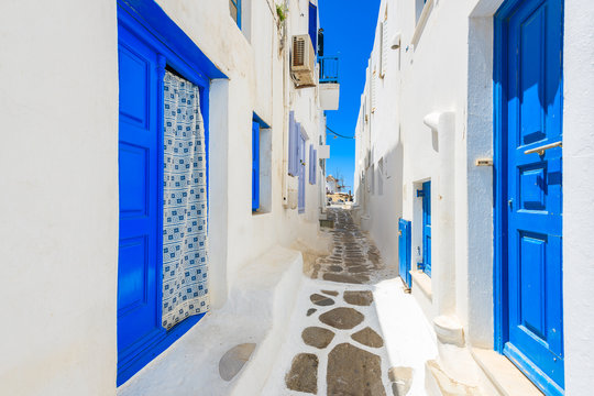 Fototapeta A view of whitewashed street with blue doors in Mykonos town, Cyclades islands, Greece