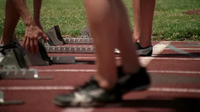 Close-up of starting blocks and racers' feet