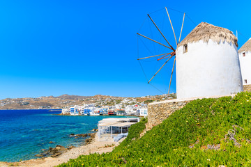 White traditional windmill overlooking Mykonos port, Cyclades islands, Greece © pkazmierczak
