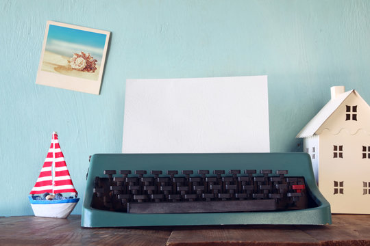 Photo of vintage typewriter with blank page on wooden table