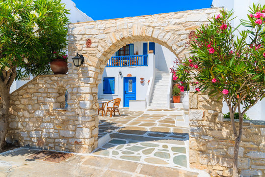Fototapeta Beautiful Greek style holiday apartments on street of Naoussa village, Paros island, Cyclades, Greece