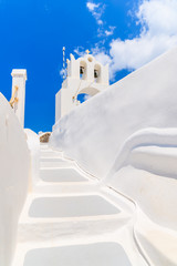 Fototapeta premium Steps in Oia town leading to typical white church, Santorini island, Cyclades, Greece