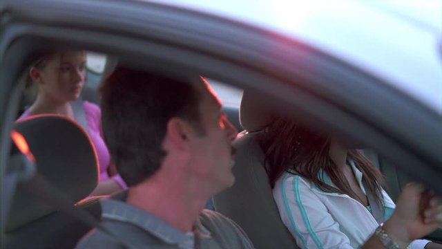 Close-up of driver's ed instructor and students in car