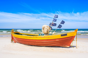 Colorful fishing boat on sandy Baltic Sea beach, Poland