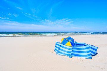 A wind breaker with tent on white sand beach in Debki coastal village, Baltic Sea, Poland