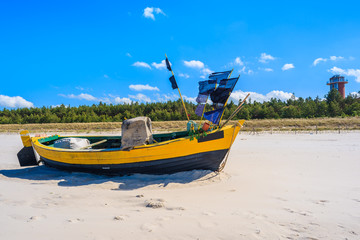 Colorful traditional fishing boat on sandy Baltic Sea beach in Debki, Poland