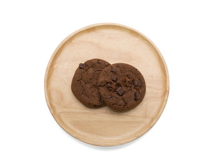 Chocolate cookies with chocolate chip on round wooden plate from top view isolated on white background