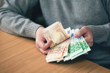 hands holding Euro banknotes, the currency value of 50 and 100 Euro