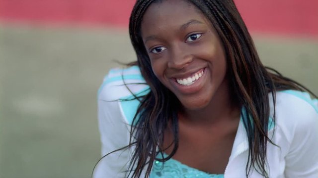 Portrait of smiling seated girl with tiny braids
