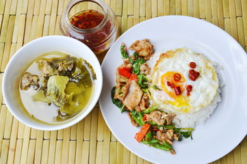 spicy stir fried pork and basil leaf on rice eat with pickled cabbage soup