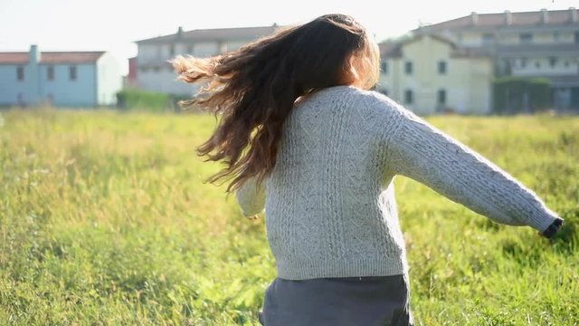 Spinning around in meadow