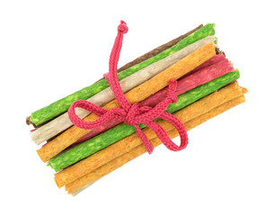 Group of beef hide dyed dog snacks tied with cord top view isolated on a white background.