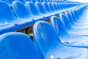 Naklejka premium Empty plastic blue chairs at stadium in a row. Closeup.