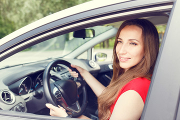 Fototapeta na wymiar Young happy woman driving a new or rented car