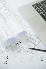 black pencil and computer laptop on architectural drawing paper for construction
