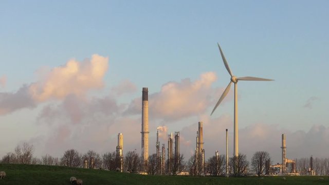 Wind turbine against oil refinery