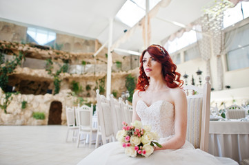 Naklejka premium Portrait of charming red-haired bride model with wedding bouquet