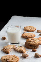 Cookies pile with chocolate chip and almond on light textile background. Delicious morning snacks for breakfast, brunch and lunch. Appetizing, healthy and fast food
