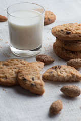 Cookies pile with chocolate chip and almond on light textile background. Delicious morning snacks for breakfast, brunch and lunch. Appetizing, healthy and fast food
