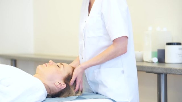 View of a Young attractive masseuse doing a capillariy massage