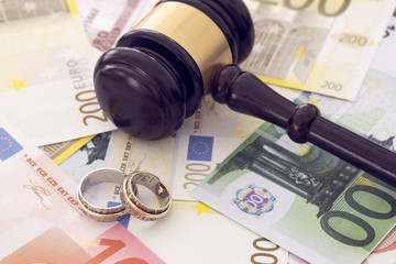Family law concept, gavel, rings and money on wooden table