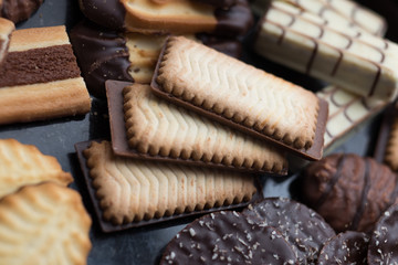 Cookies assorted on black background. Delicious morning snacks for breakfast, brunch and lunch. Appetizing, sweet and fast food.
