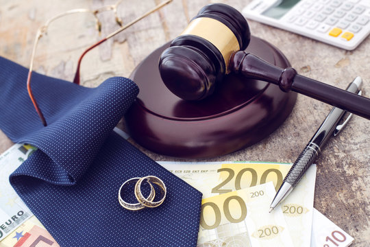 Family law concept, gavel, rings and money on wooden table