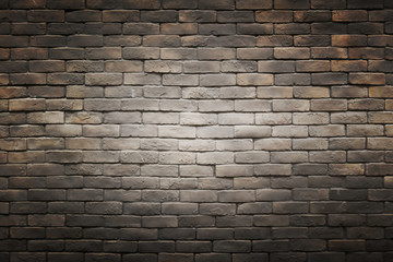 dark black brown gray brick wall background with light gradient circle in the middle