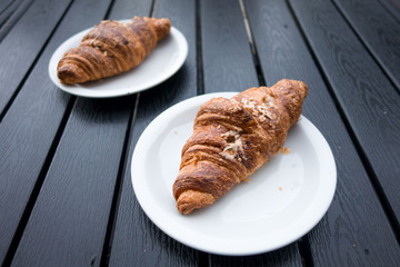 Brioches farcite su  piattini appoggiati su un tavolo di legno a doghe grigio antracite