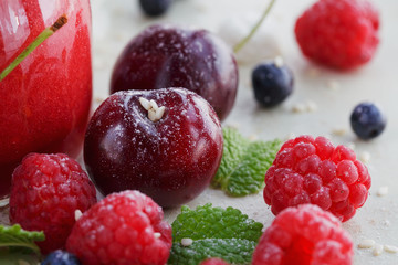 Raspberry, sweet cherry and bilberry on white wooden background.