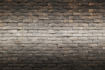 dark black brown gray brick wall background with horizontal light gradient line in the middle