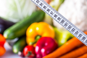Measuring tape and Fresh vegetable and fruits in the background. Healthy diet  concept..