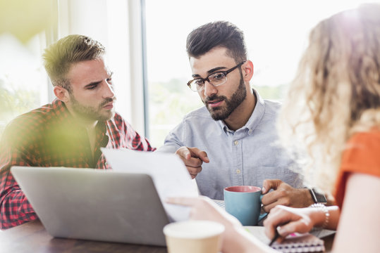 Three young professionals having a meeting in office