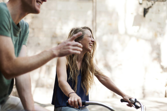Laughing woman with bicycles beside her partner
