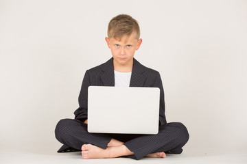 junger Mann in Anzug sitzt mit Schild auf Boden