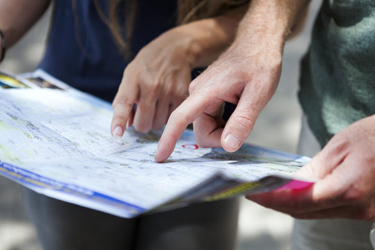 Couple's hands pointing on city map